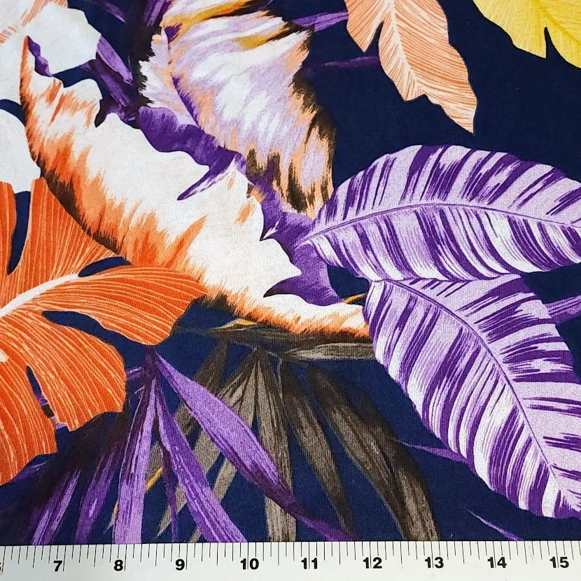 Lightweight Cotton Knit Fabric, Pretty Purple, Coral, and Yellow Tropical Print on Navy. 2-way stretch. Sold by the 1/2 yard